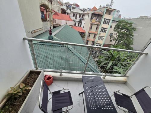 a balcony with two chairs and a bench on a building at The Chilling'N Homestay Ha Noi 89 in Hanoi