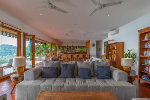 a living room with a large couch with blue pillows at Paradise Garage Komodo Villa in Labuan Bajo