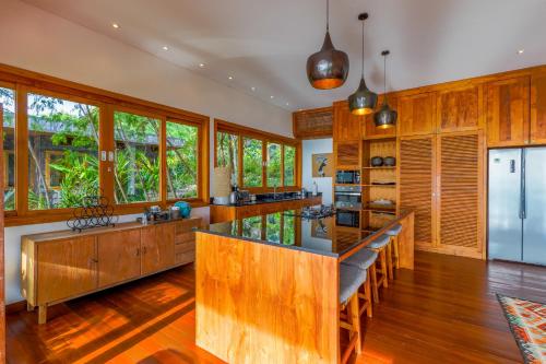 a kitchen with wooden cabinets and a large island with benches at Paradise Garage Komodo Villa in Labuan Bajo
