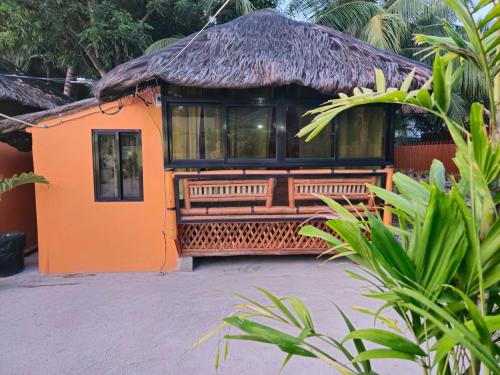 an orange house with a thatched roof at Casa Celine Dumaguete in Dumaguete