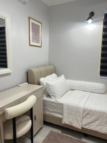 Un dormitorio con una cama, un escritorio y una silla. en amliza homestay, en Cyberjaya