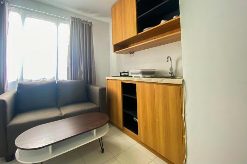 a small room with a table and a chair at Comfort 1BR at Patraland Urbano Apartment By Travelio in Bekasi