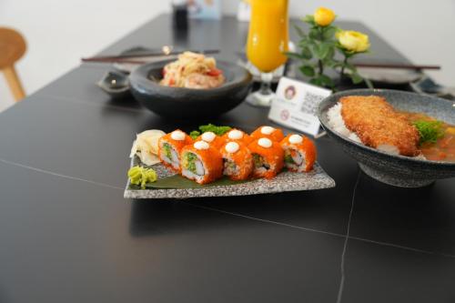 a table with two plates of sushi and bowls of food at AG Hotel in Abu Dhabi