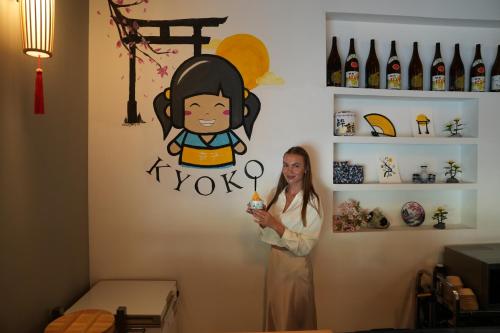 a woman standing in front of a wall with a painting of a girl at AG Hotel in Abu Dhabi