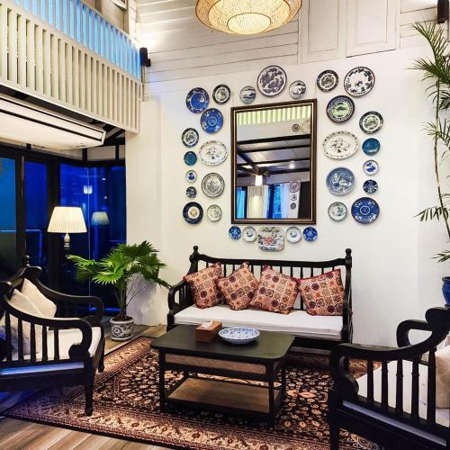 a living room with blue and white plates on the wall at Siraburi boutique pool villa at Center of old town in Chiang Mai