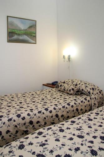a bedroom with a bed with a floral bedspread at Hotel Villa Neretva - Metković in Metković