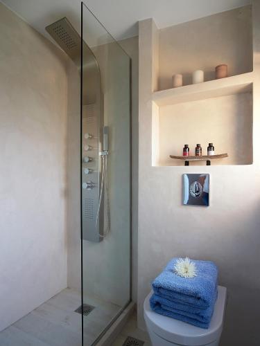 a bathroom with a shower and a toilet with a blue towel at Villa Niolos I in Marathi