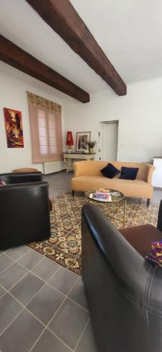 - un salon avec deux canapés et un tapis dans l'établissement Une maison de famille dans le Luberon, à Bonnieux