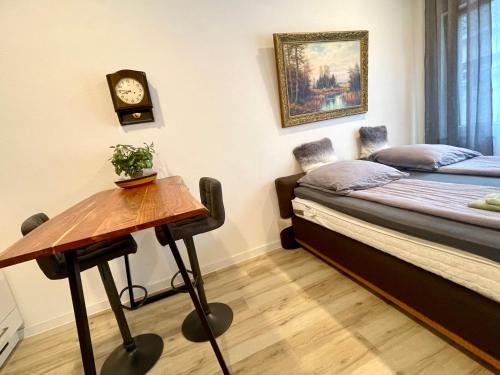 a room with a bed and a table with a clock at Wunderschönenes Apartament am Schlössle Zentrum Goldstadt in Pforzheim