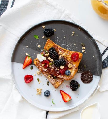 a plate with two pieces of toast and berries at Harmonious Greens: Cozy 1-Bed Flat in Harrow in Harrow