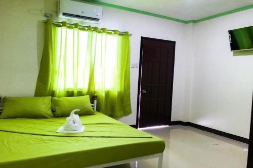 a bedroom with a green bed with a white duck on it at Diane Sunshine Villa Panglao near Beach in Panglao