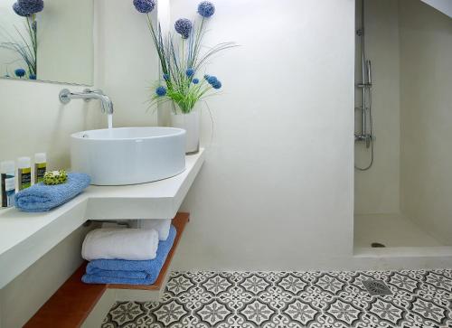 a white bathroom with a sink and a shower at Villa Niolos I in Marathi