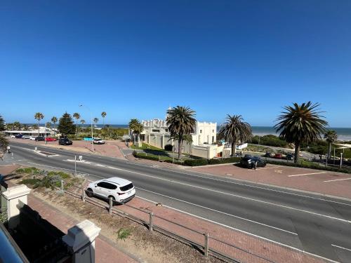 a white car parked on the side of a highway at 1 95 Esplanade, Semaphore in Semaphore
