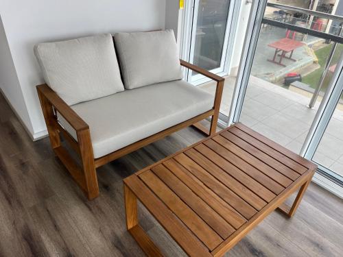 a chair and a coffee table in front of a window at 1 95 Esplanade, Semaphore in Semaphore