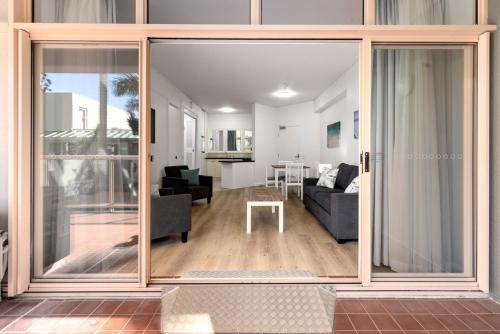 a living room with sliding glass doors leading into a living room at Charlesworth Bay Beach Resort in Coffs Harbour