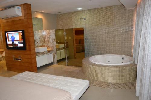 a large bathroom with a tub and a tv in it at Apartamento Fortaleza Beira Mar in Fortaleza