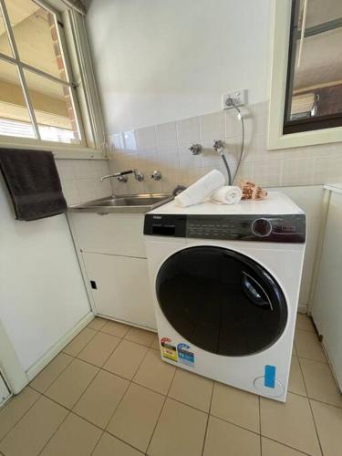 a microwave in a kitchen with a sink at Hampton Spacious House & Pool in Melbourne