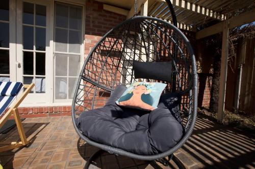 a circular chair with a pillow in it on a patio at Hampton Spacious House & Pool in Melbourne