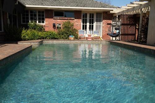 a large pool of water in front of a house at Hampton Spacious House & Pool in Melbourne