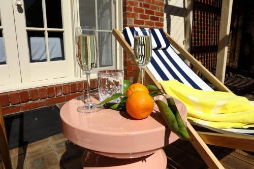 a table with two wine glasses and oranges on a porch at Hampton Spacious House & Pool in Melbourne