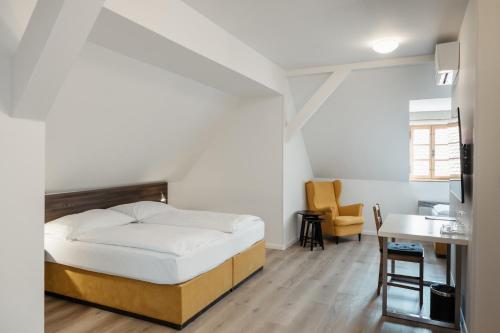 a bedroom with a bed and a desk in it at Penzion Austis in Znojmo