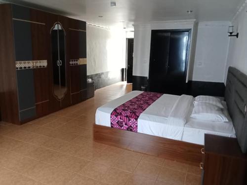 a bedroom with a large bed and a bathroom at Puataukanave International Hotel in Neiafu