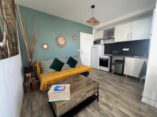 un salon avec un canapé et une cuisine dans l'établissement Appartement à 100m de la plage, à La Barre-de-Monts