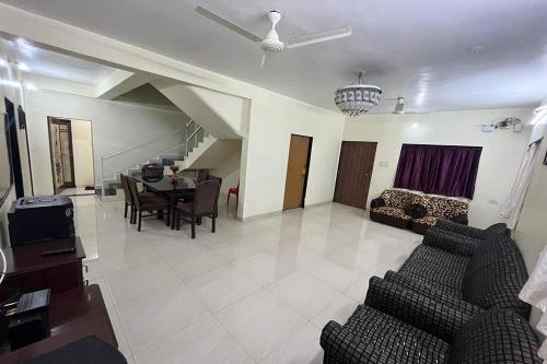 uma sala de estar com um sofá e uma mesa em Savitri Bungalow em Panchgani