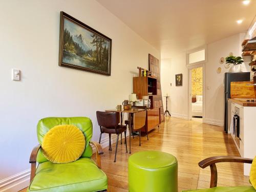 a living room with green chairs and a table at Park views, fast wifi, washer & dryer in Auckland
