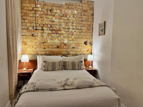 a bedroom with a brick wall and a bed at Park views, fast wifi, washer & dryer in Auckland