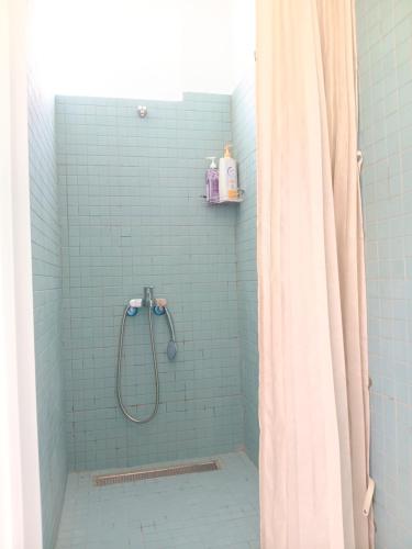 a bathroom with a shower with blue tiles at 高一 33 班 Homestay 1982 in Chenggong