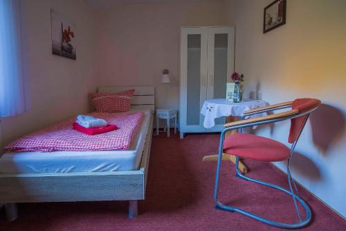 a small bedroom with a bed and a chair at Pension Haus Brückner in Wildemann