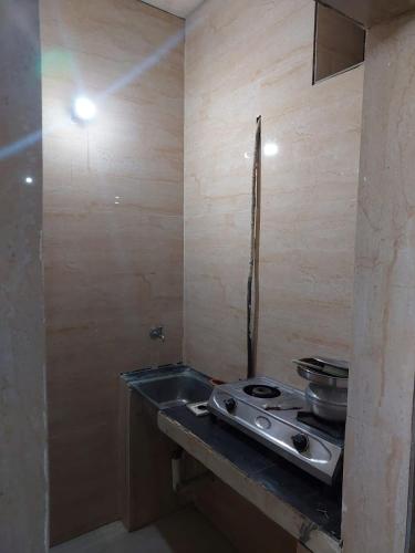 a kitchen with a stove and a sink at Xavier Guest House in Chennai