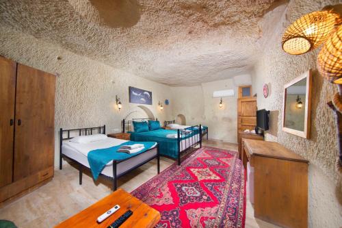 a bedroom with two beds and a living room at World Cave House - Hotel & Swimming Pool in Ürgüp