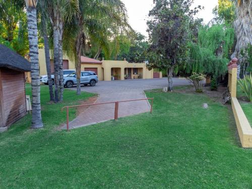 a driveway of a house with a parking lot at Sunriver Kalahari Lodge Riverside stay in Upington in Upington