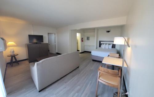 a hotel room with a bed and a couch at MC Pacific Inn & Suites Torrance in Torrance