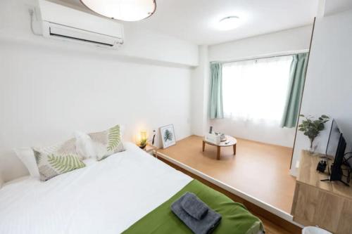 a white bedroom with a large bed and a window at 今和Hotel in Tokyo