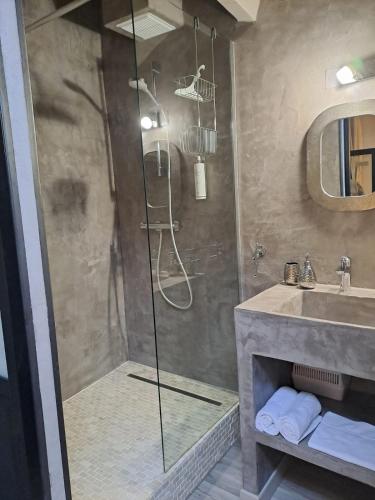 ein Badezimmer mit Dusche und Waschbecken in der Unterkunft L Antre de Pierres - chambres d'hôtes et gites in Berrias Et Casteljau