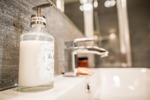 a bottle of milk sitting on a bathroom sink at Apartment Extra Home in Kielce
