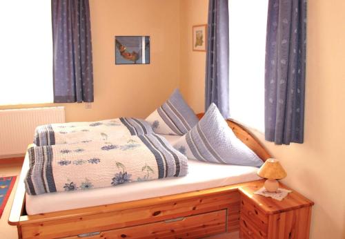 a bedroom with a bed with blue curtains and a window at Haus Reese in Buntenbock