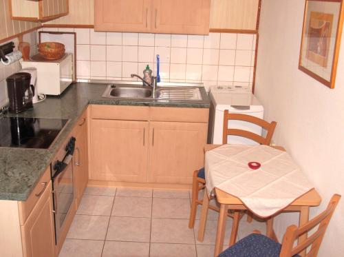 a kitchen with a sink and a table with chairs at Haus Reese in Buntenbock