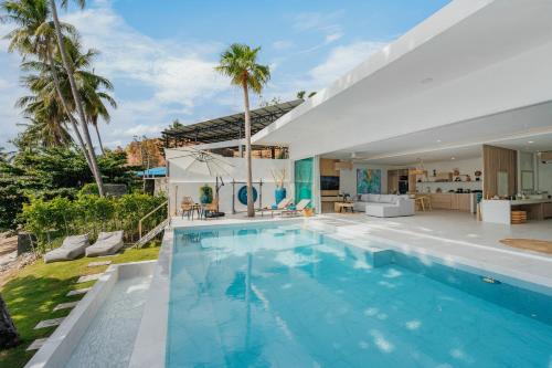 a swimming pool in the backyard of a house at Beachfront Secret Tides Villa Tierra in Bangrak Beach