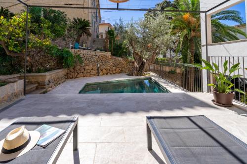 a swimming pool in a yard with a hat at Sa Caleta in Port de Soller