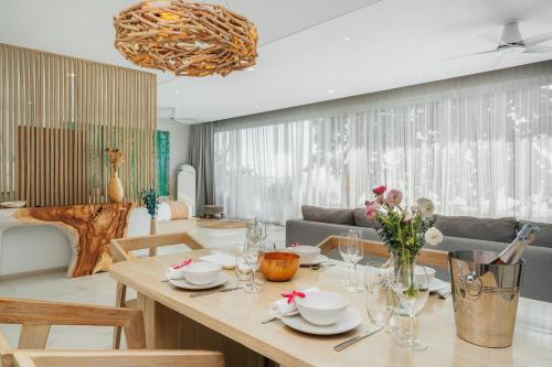 a dining room with a table and a couch at Beachfront Secret Tides Villa Tierra in Bangrak Beach