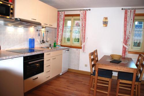 a kitchen with a table and a small table and chairs at FH Am Osterbrunnen in Hinterhermsdorf