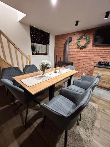 a dining room with a table and chairs and a fireplace at Siedlisko Złota Góra domki całoroczne na Kaszubach in Brodnica