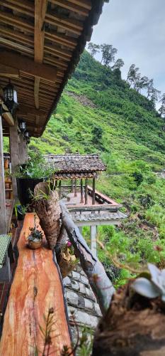 a porch of a house with a hill in the background at Homestay Huyền Thoại Cao Nguyên Đá in Lao Ou Tchai