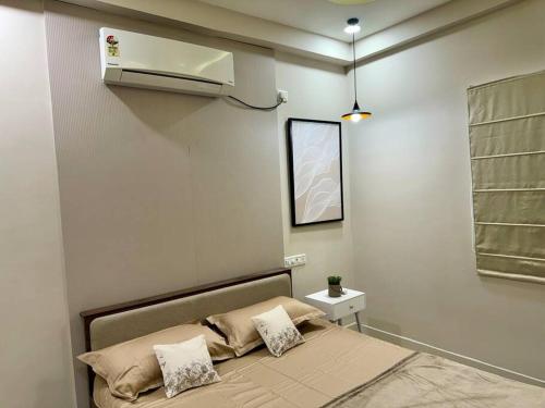 a bedroom with a bed with pillows on it at Emerald Suites 3BHK - Madhapur in Hyderabad