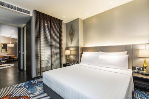 a bedroom with a large bed with white pillows at Chatrium Hotel Riverside Bangkok in Bangkok