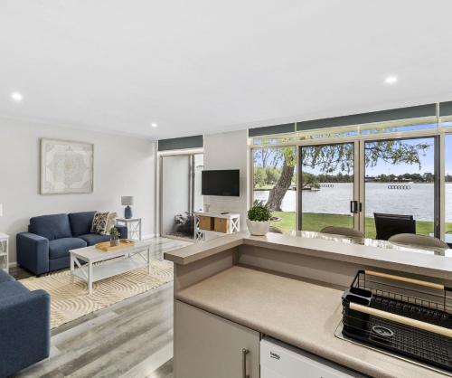 a living room with a blue couch and a tv at Yarrawonga Lakeside Apartment 27 in Mulwala